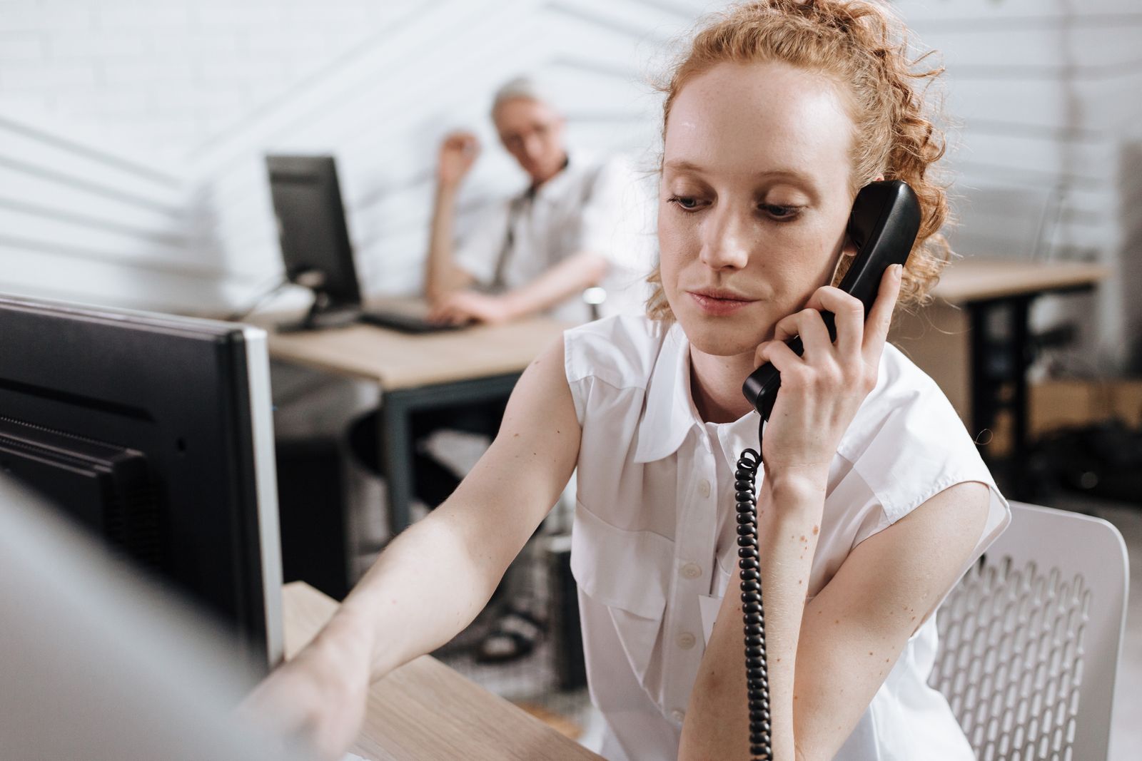 Recepcionista confirmando horários por telefone em uma clínica